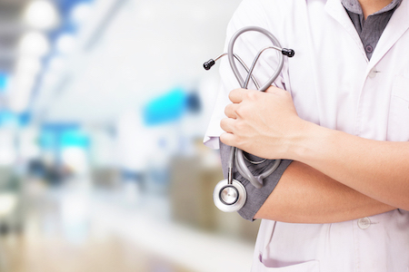 Doctor with a stethoscope in the hands and hospital background